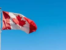 A Canadian flag blows majestically in the wind.