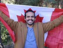 Proud man smiling while holding the Canadian flag