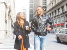 Two happy people walking down a street in Toronto.