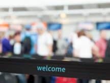 A divider in the immigration line at the airport, with the word "welcome" printed on it.