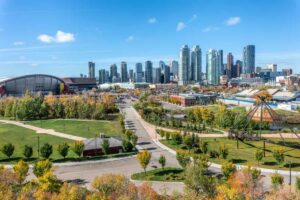 A cityscape view of Downtown Calgary featuring buildings, greenery and roads.