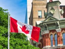 A Canadian flag waving with a tree, and both modern and classical buildings in the background.