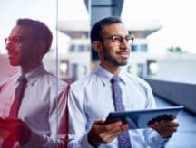 Picture of a man smiling and holding a tablet