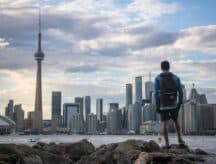 A man views the CN tower from a distance on a cloudy summer day