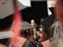 A group of graduates in ceremonial dress, at their convocation speech.