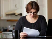 Woman stares at paperwork.