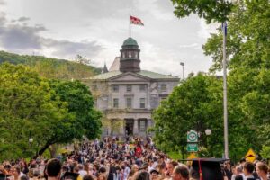 A mass of students in front of a building on Quebec's McGill University campus