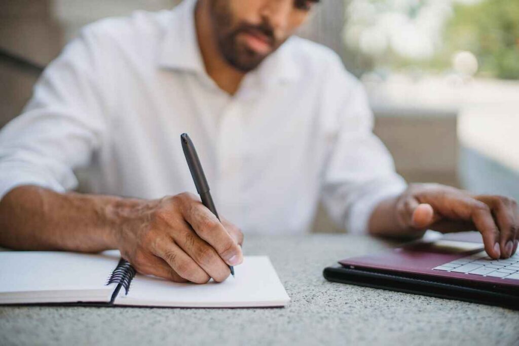 Man Watching Webinar and Taking Notes