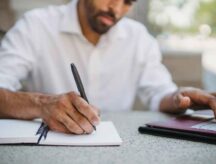 Man Watching Webinar and Taking Notes