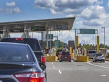 A picture of the Canada-US border, with a line of cars waiting for service.