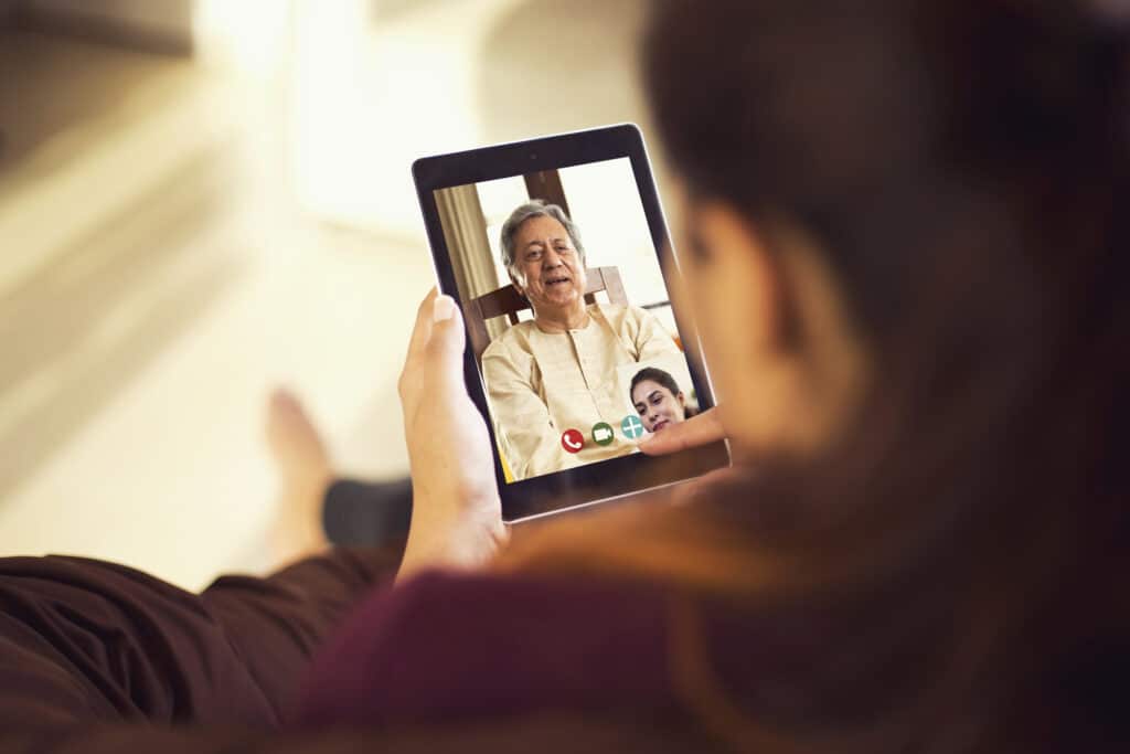 Hija hablando por videollamada con su padre usando una tableta digital