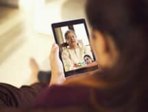 Daughter talking on video call with her father using digital tablet