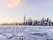 A skyline of the city of Toronto, behind a frozen lake