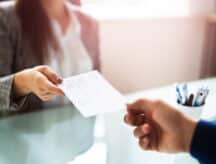 A woman hands a man a cheque