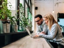 A couple sits at a desk applying for their SOWP so they may both work in Canada.