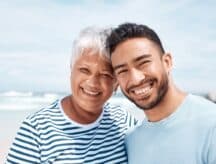 A woman and her adult son enjoying a day at the beach.