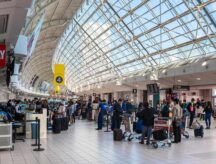 People carry luggage in a busy airport/