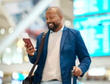 A man looks at his passport and flight ticket in an airport