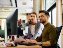 Two young professionals working in a modern looking office